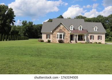 Beautiful Landscaped Yard With A Brick Home Surrounded By A Forest On A Bright Day