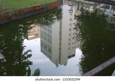 beautiful and large building reflected in the water of a lake in a public square