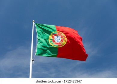Beautiful large Portuguese flag waving in the wind against blue sky. Portuguese Flag Waving Against Blue Sky. Flag of Portugal waving, against blue sky 
