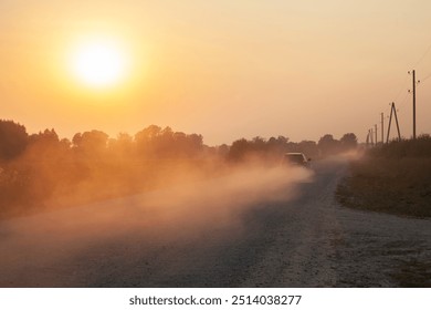 Beautiful late summer evening landscape with car driving on the dusty road in sunset in Latvia country side. 