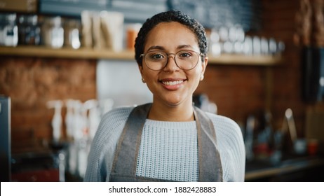 Beautiful Latin American Female Barista with Short Hair and Glasses is Projecting a Happy Smile in Coffee Shop Bar. Portrait of Happy Employee Behind Cozy Loft-Style Cafe Counter in Restaurant. - Shutterstock ID 1882428883