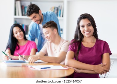 Beautiful Latin American Female Student Learning With Group Of Students At Classroom Of School