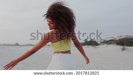 Beautiful Latin American woman on the beach. Young woman enjoying her summer vacation on a sunny day, smiling and looking at the camera