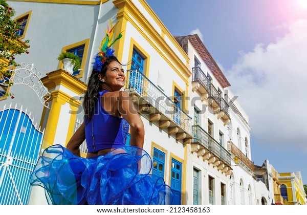 Beautiful\
Latin dancer dressed up for Carnival on the streets of Olinda.\
Frevo Recife. Brazil colors. Historical\
city.