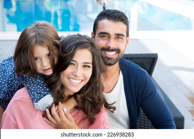 Beautiful Latin Family Relaxing Close To The Pool