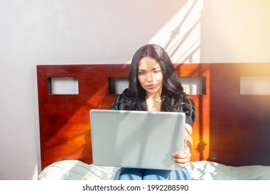 Beautiful Latin Girl Using Laptop To View Her Social Networks In Room. Mexican Woman Shopping Online