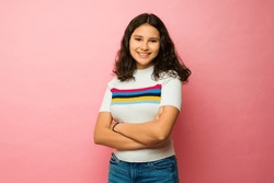 Beautiful Latin Teen Girl Smiling Wearing Casual Clothes Looking Happy Against A Pink Studio Background