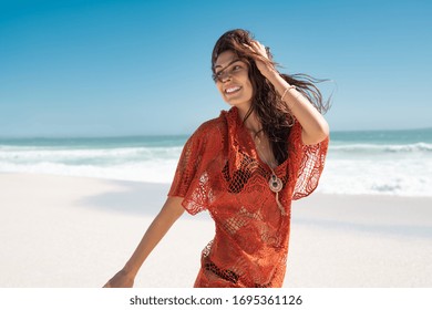 Beautiful Latin Woman Running On Tropical Beach With Copy Space. Happy Glamour And Carefree Woman Walking On Beach While Looking Behind. Stylish Girl With Black Bikini Enjoying Summer Vacation At Sea.