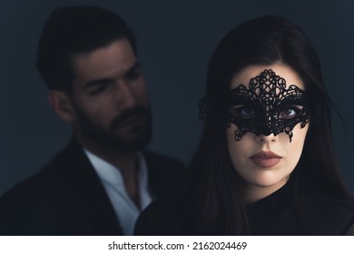 beautiful Latin woman with theatrical mask and handsome Latin American man over black background. High quality photo