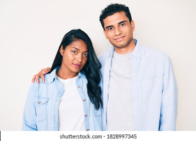 Beautiful Latin Young Couple Wearing Casual Clothes Relaxed With Serious Expression On Face. Simple And Natural Looking At The Camera. 