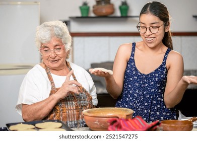 Beautiful Latina granddaughter makes corn tortillas with her loving grandmother. - Powered by Shutterstock