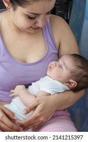 Beautiful Latina Woman Holding In Her Arms Her Beautiful Baby Girl Who Is Sleeping After Feeding From Her Mother's Breast. Two Month Old Baby Girl Resting On Her Mother's Legs.