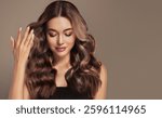 Beautiful laughing brunette model  girl  with long curly  hair . Smiling  woman hairstyle wavy curls .     Fashion , beauty and makeup portrait