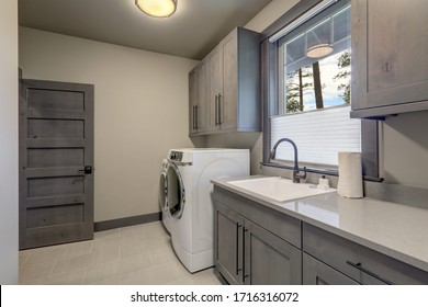 Beautiful Laundry Room With Rish Wooden Doors And White Washer And Dryer.