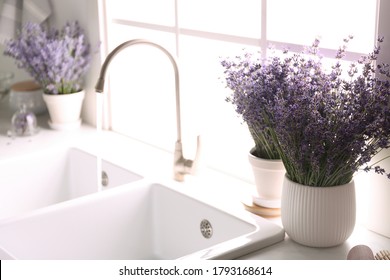 Beautiful Lavender Flowers On Countertop Near Sink In Kitchen