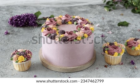 A beautiful lavender-hued cake, adorned with creamy flowers in assorted colors, showcasing intricate detail and artistry
