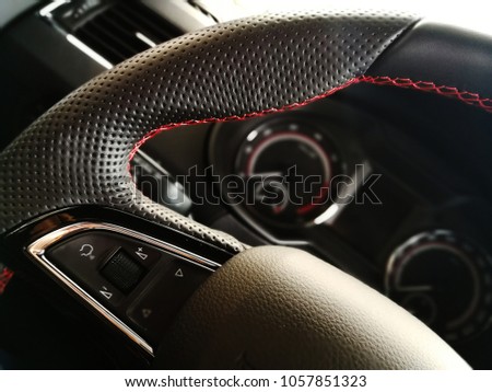 beautiful leather steering wheel on the background of a speedometer