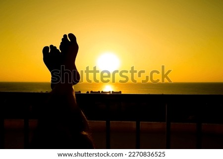 Beautiful legs at the dawn silhouette of the sea background