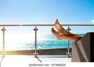 Beautiful legs resting on sofa woman with background on sea landscape.