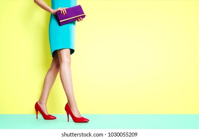 Beautiful Legs Woman Walking With Red Heels Shoes. Isolated On Yellow Background. Spring Fashion Image.