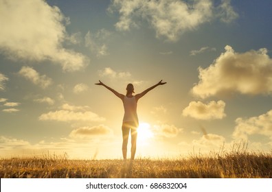 It's a beautiful life. Happy people lifestyle. Young woman in a nature setting with her arms in the air feeling free and energized.  - Powered by Shutterstock