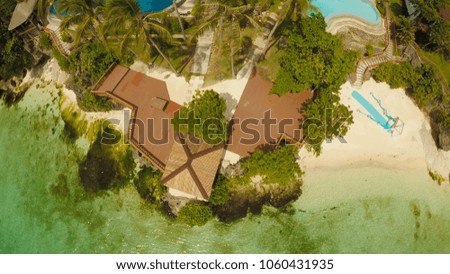 A beautiful light green coast with reefs and a loving couple on the balcony above the beach. The beautiful nature of the Philippines. Aerial view. Near open pool.
