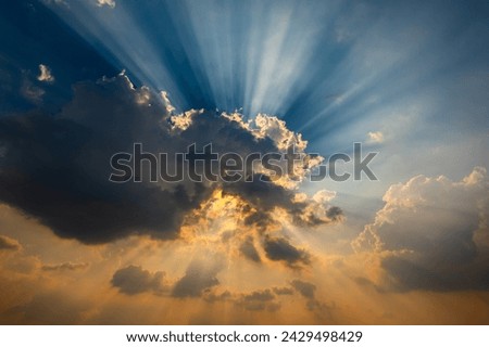 Beautiful light Sun shines behind the cumulus clouds.Colorful sunrise with Clouds over hill.Sun hiding behind a cloud on the day sky.Sunray with dark Clouds sunset.