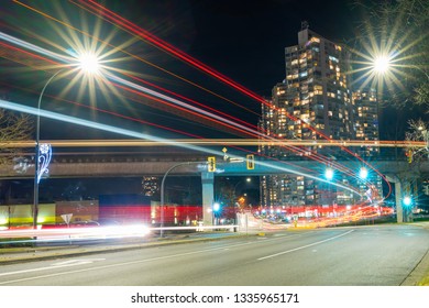 A Beautiful Light Trails Created By Both The Road Vehicles And A Skytrain Crossing The Frame On A Skybridge In The City Of Surrey, BC, Canada.