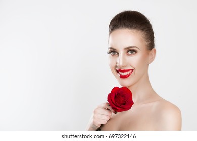 Beautiful like flower   Happy woman holding red rose  smiling looking at you the camera isolated white background  Brunette  dark hair  false eyelashes natural makeup red black gradient lips nails