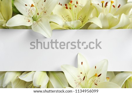 Beautiful lily flowers and blank card, top view