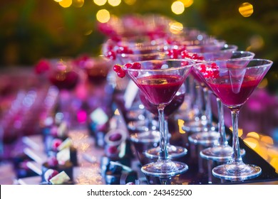 Beautiful line of different colored cocktails with smoke on a Christmas party, tequila, martini, vodka, and others on decorated catering bouquet table on open air party  - Shutterstock ID 243452500
