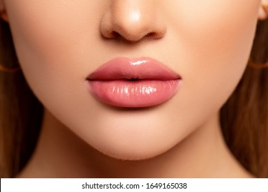 Beautiful Lips Close-up. Makeup. Lip shiny Lipstick. Sexy Lips. Part of Face, Young Woman close up. Perfect plump Lips bodily  Lipstick. Peach Color of Lipstick on Large Lips. Perfect Makeup     