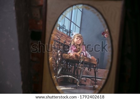 Beautiful litle young girl model posing. Little cute girl background vintage and old mirror