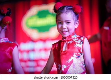 Beautiful little asian girl in red chinese dress.