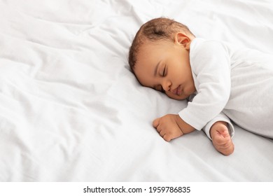 Beautiful Little Baby Boy Sleeping Peacefully Lying On Side In Bed Indoors, Resting During Daytime Sleep With Eyes Closed. Toddler Child Napping Indoors. High Angle, Cropped Shot With Copy Space