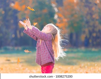 Beautiful little blonde hair girl, has fun smile face, happy emotions, dressed woolen coat. Plays falling leaves. Child portrait. Creative concept. Autumn time. Close up. Fashion kid style. - Shutterstock ID 1008275200