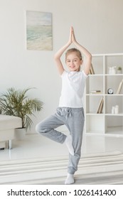 Beautiful Little Child Practicing Yoga In Tree Pose