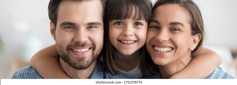 Beautiful little daughter cuddles loving mother caring father cheerful parents close up, people making picture together. Happy family portrait concept horizontal photo banner for website header design
