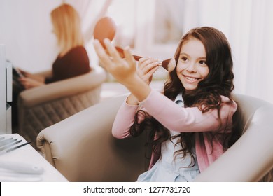 Beautiful Little Girl. Girl in Beauty Salon. Girl Makes Makeup. Smiling Girl Looks in Mirror. Famale Child Sitting in Chair. Baby Makeup Artist. Beautiful Little Woman in Salon. Children's Makeup.