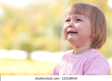 beautiful little girl crying on the autumn forest