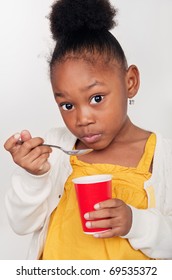 Beautiful little girl eating healthy yogurt