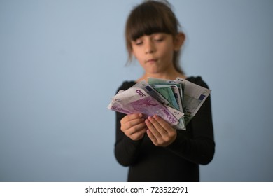 Beautiful little girl holding euro cash banknotes - Shutterstock ID 723522991