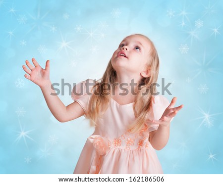 beautiful little girl on blue background with snowflakes