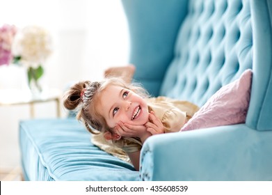 Beautiful Little Girl Playing On The Couch