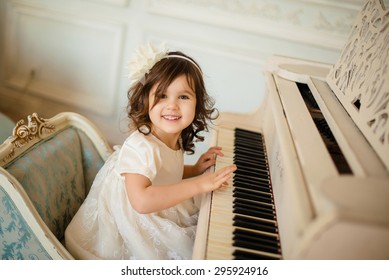beautiful little girl playing piano in light room - Powered by Shutterstock