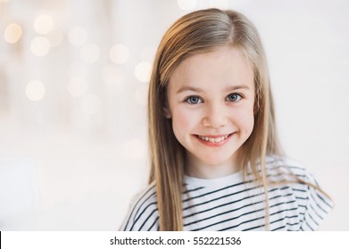 Beautiful Little Girl Portrait At Home. Cute Child Smiling And Looking At Camera