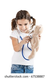 Beautiful little girl pretending to be a nurse and auscultate her teddy-bear