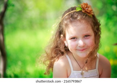 Beautiful Little Girl Sitting On Grass And Looking Up. Happy Baby On Walk. No Mobile Phone And Other Gadgets.