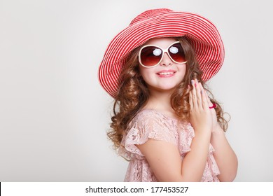 Beautiful little girl in summer hat and sunglasses on white background, portrait of cute happy child baby girl in lace princess dress in studio. kid summer fashion. isolated.