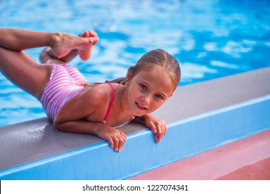 Beautiful little girl swims in the pool , cute little girl in pool in sunny day.little girl .